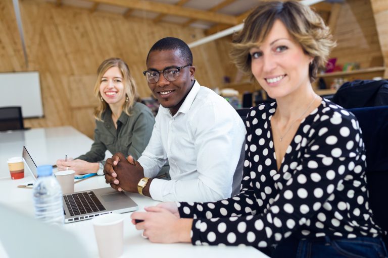 Successful smiling business team working together while looking